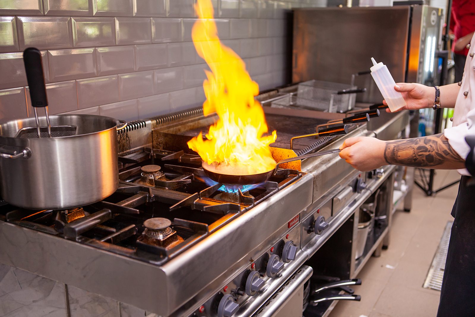 Chef flambéing in a professional kitchen